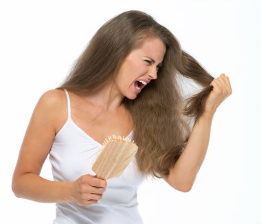 Stressed young woman combing hair clipart