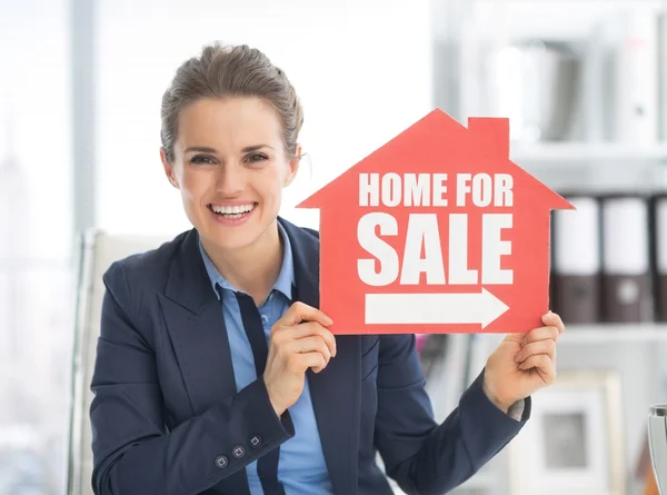 Mujer inmobiliaria mostrando signo de venta — Foto de Stock