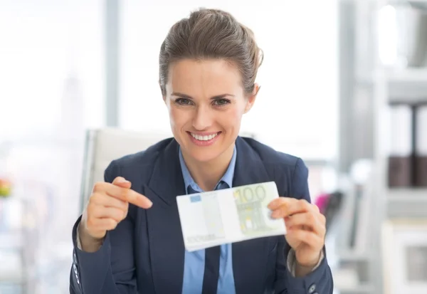 Mujer de negocios apuntando al paquete de dinero —  Fotos de Stock