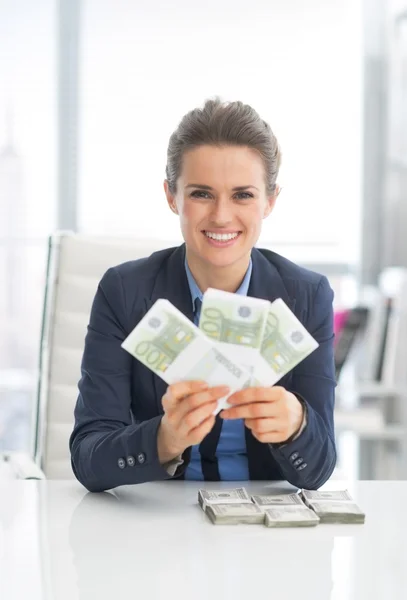 Mulher de negócios mostrando pacotes de dinheiro — Fotografia de Stock