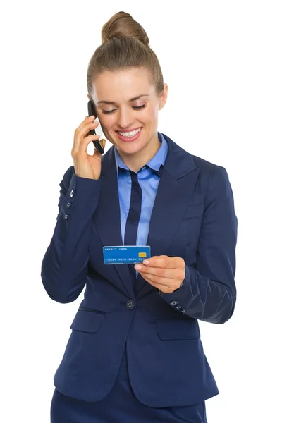 Businesswoman with credit card talking cell phone — Stock Photo, Image