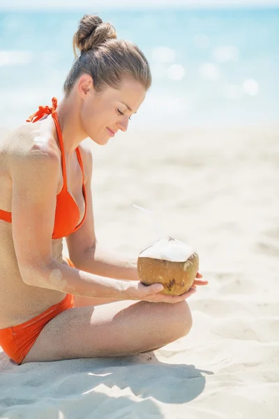 Vrouw met kokos op strand — Stockfoto