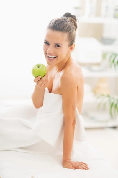 Femme assise avec pomme sur une table de massage — Photo