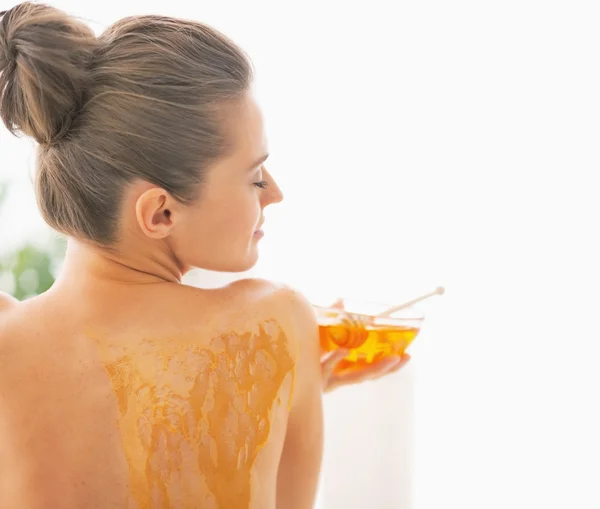 Mujer joven disfrutando de la terapia de spa miel. visión trasera —  Fotos de Stock