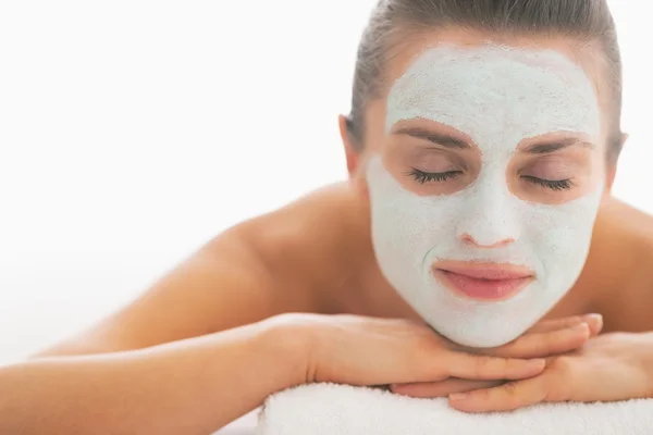 Young woman with revitalising mask on face laying on massage tab — Stock Photo, Image