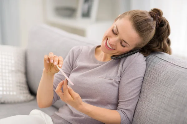 Vrouw praten mobiele telefoon en het maken van manicure — Stockfoto