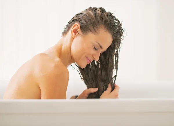 Mulher feliz lavando o cabelo na banheira — Fotografia de Stock