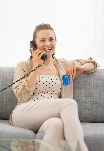 Mulher com cartão de crédito falando telefone — Fotografia de Stock