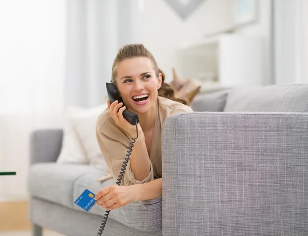 Frau mit Kreditkarte auf Sofa liegend — Stockfoto