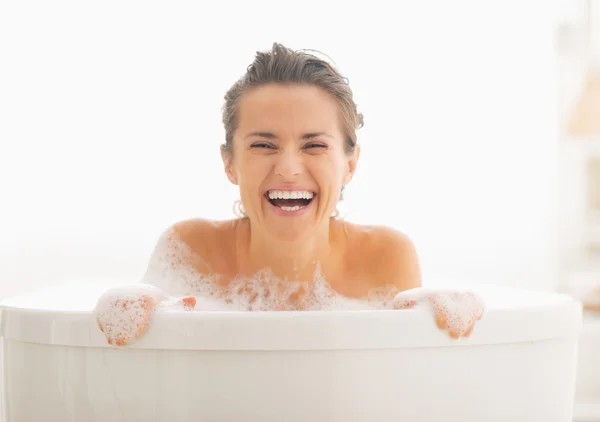 Donna sorridente che guarda fuori dalla vasca da bagno — Foto Stock