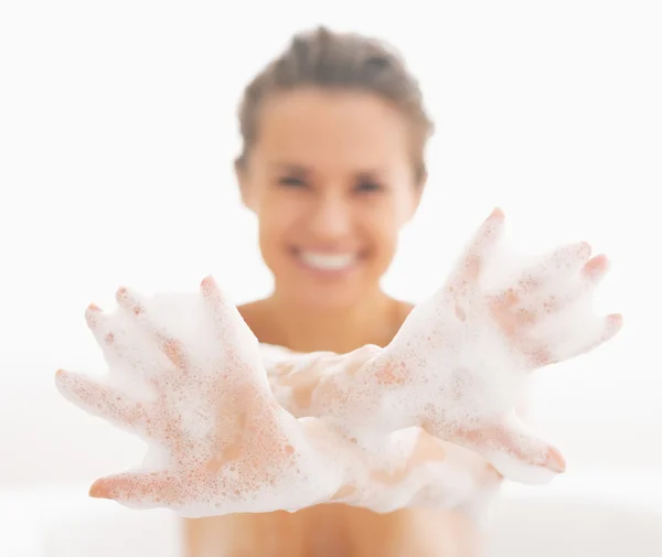 Mujer joven mostrando las manos en espuma —  Fotos de Stock