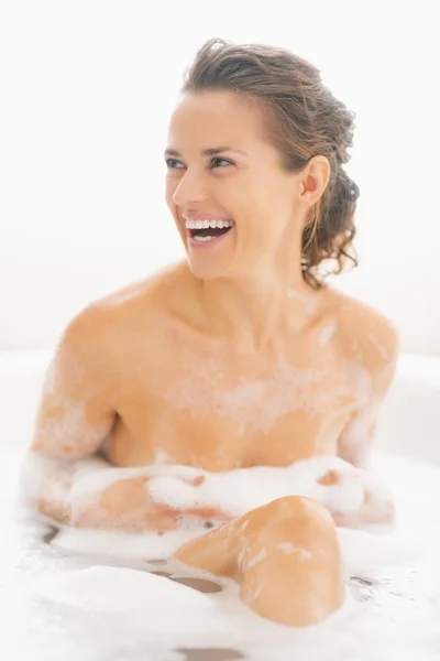 Smiling young woman sitting in bathtub — Stock Photo, Image