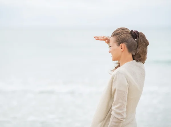 Femme regardant loin sur la plage — Photo