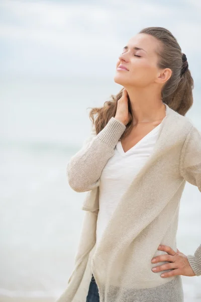 Entspannte junge Frau am kalten Strand — Stockfoto