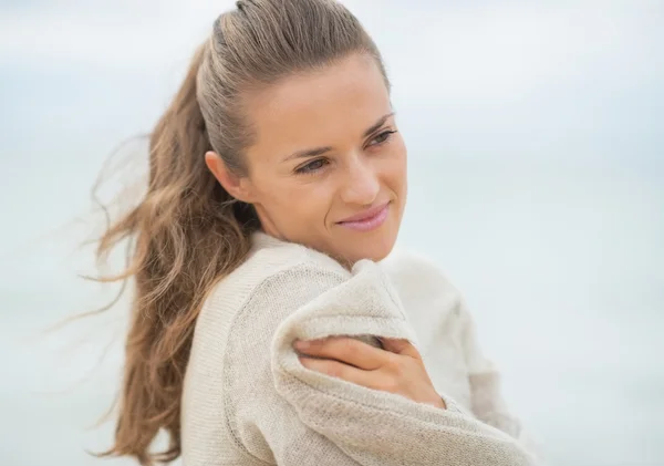 Счастливая молодая женщина на холодном пляже — стоковое фото