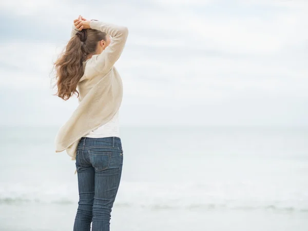 Žena na chladné pláži při pohledu do dálky — Stock fotografie
