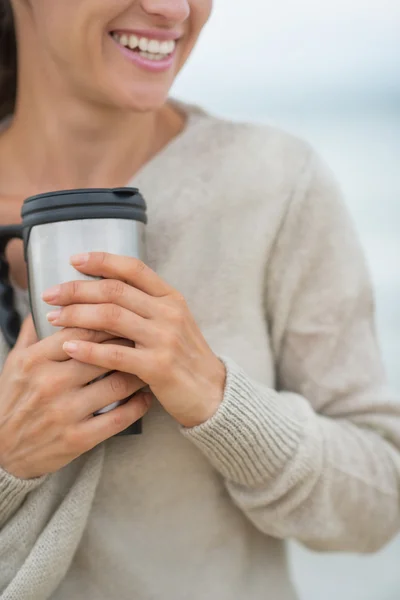 Vrouw op strand met warme drank — Stockfoto