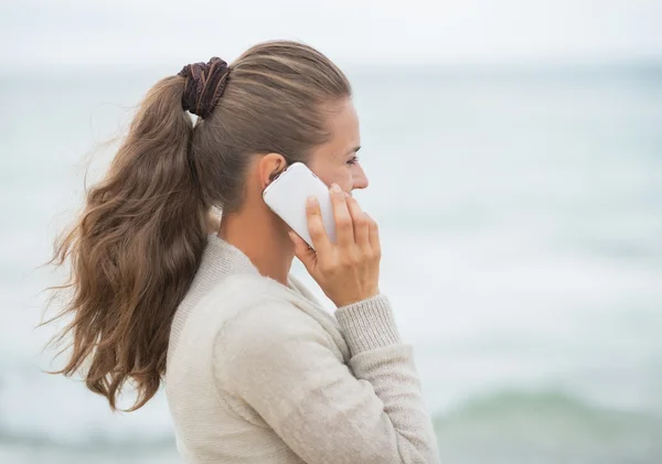 Woman talking cell phone on beach — Stock Photo, Image