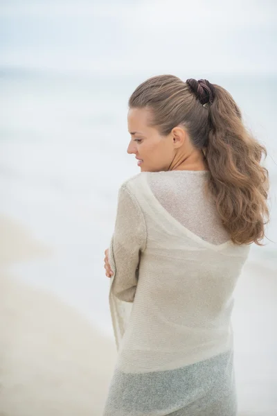 Soğuk kumsalda yürüyen genç bir kadın — Stok fotoğraf