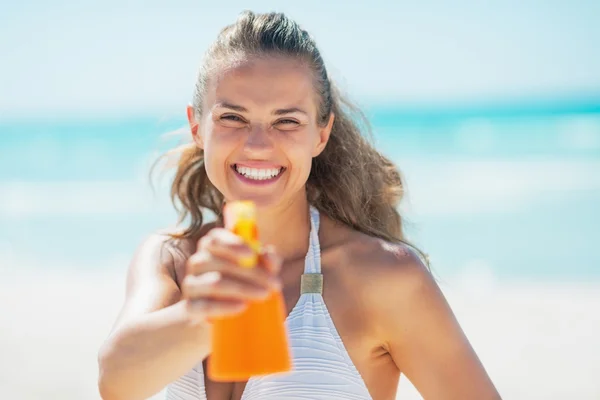 Femme pointant bouteille de crème solaire — Photo