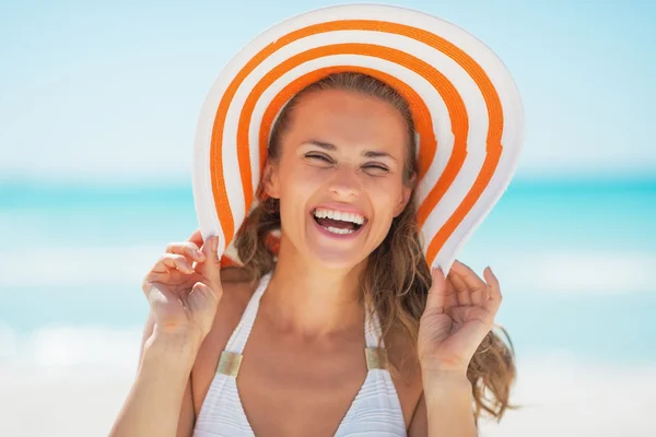 Glad kvinna i hatten på stranden — Stockfoto