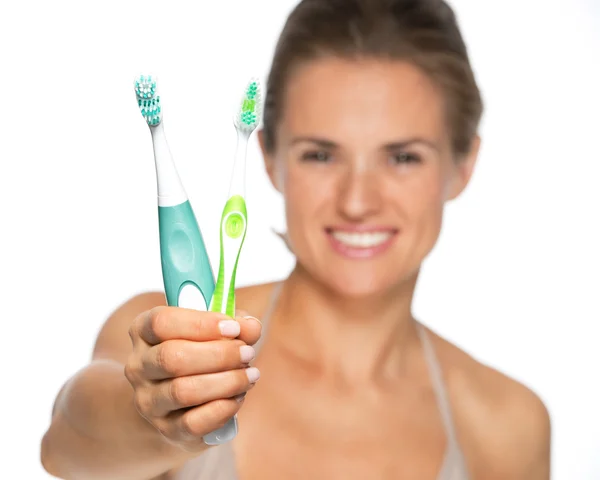 Mujer mostrando cepillo de dientes viejo y eléctrico — Foto de Stock