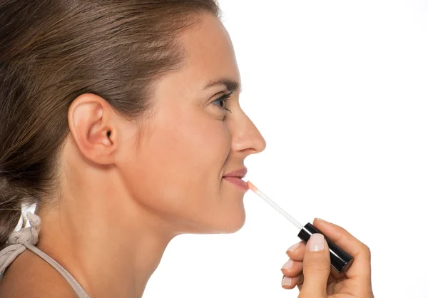 Женщина наносит блеск для губ — стоковое фото