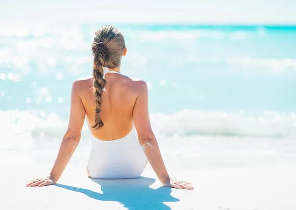 Jeune femme assise au bord de la mer . — Photo