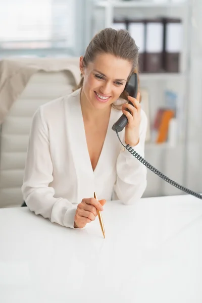 Счастливая деловая женщина говорит по телефону в офисе — стоковое фото