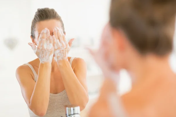 Junge Frau wäscht Gesicht im Badezimmer — Stockfoto