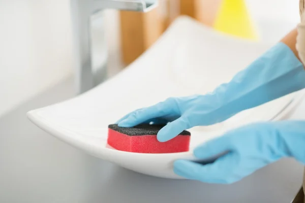 Housewife cleaning sink with sponge — Stock Photo, Image