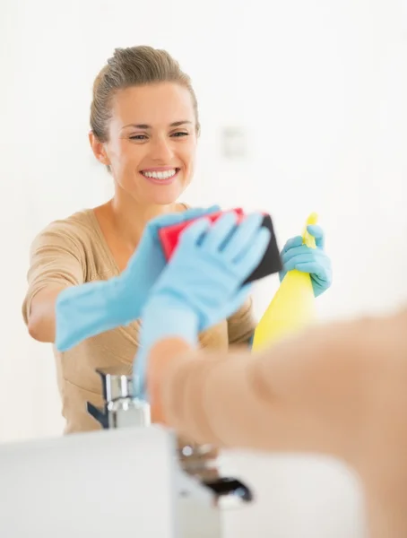 Чистящее зеркало домохозяйки в ванной комнате — стоковое фото
