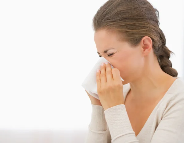 Jonge vrouw blaast neus — Stockfoto