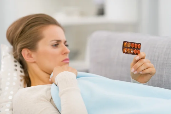 Kranke Frau schaut auf Tabletten — Stockfoto