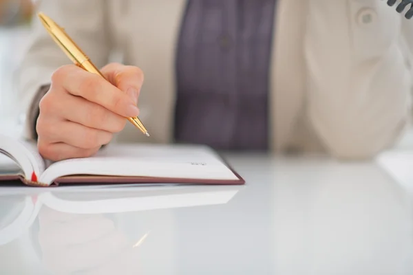 Business woman writing in diary Stock Image