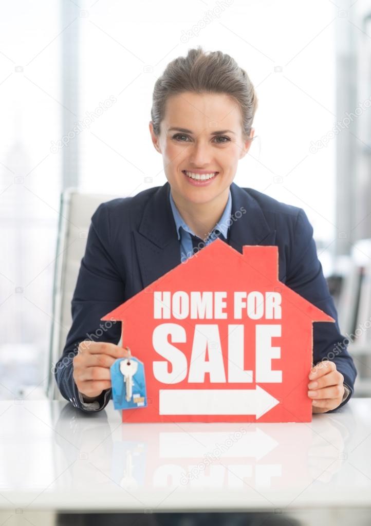 Happy realtor woman showing keys