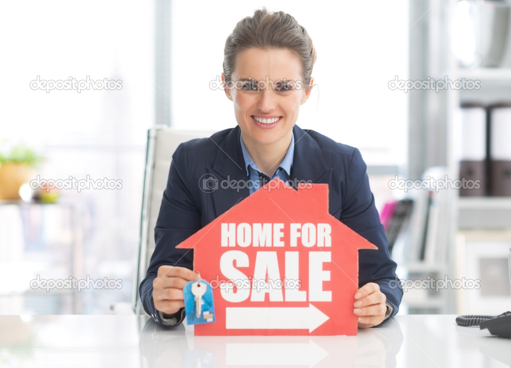Realtor woman showing keys and sign