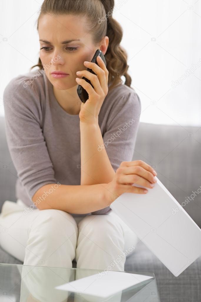 Concerned woman with letter and phone