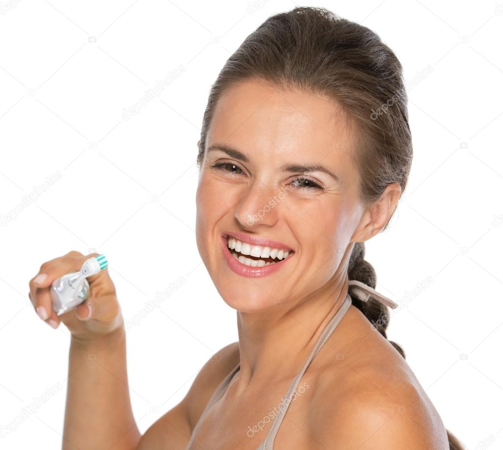 Smiling woman brushing teeth