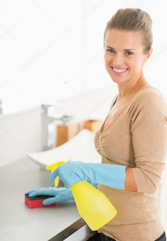 Housewife cleaning desk in bathroom