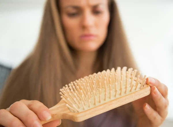 Mujer mirando peine de pelo — Foto de Stock