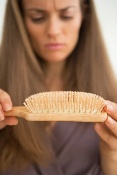 Mujer mirando peine de pelo — Foto de Stock