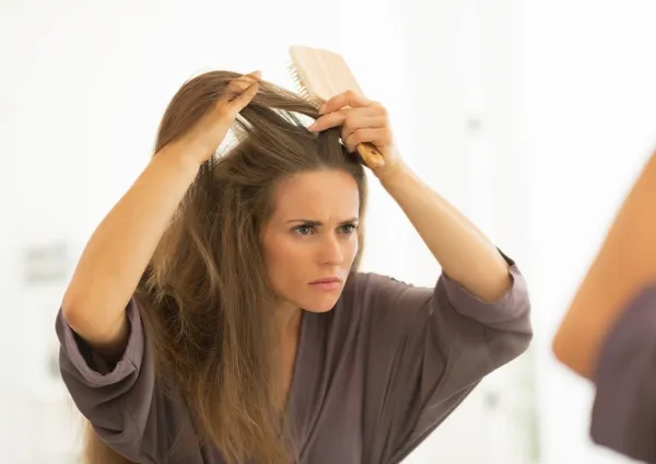 Mulher pentear o cabelo no banheiro — Fotografia de Stock