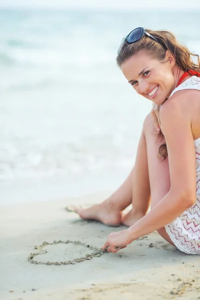 Woman drawing on sand — Stock Photo, Image