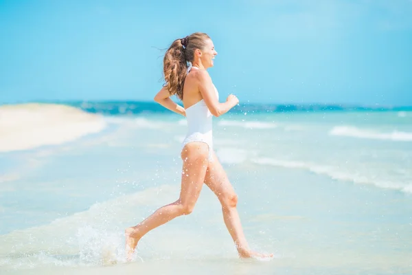 Donna che corre in mare — Foto Stock