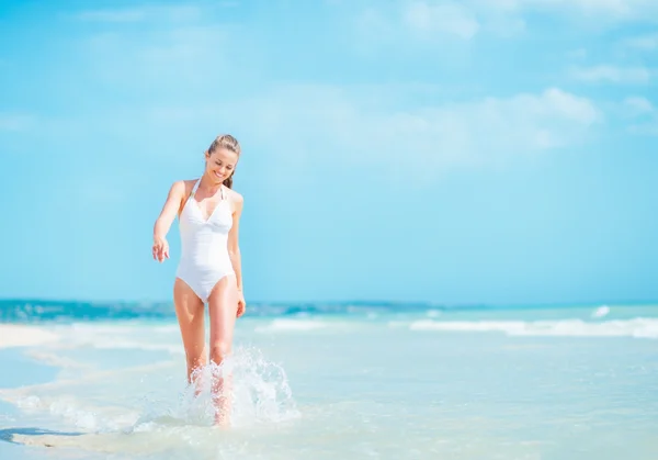 Женщина ходит по берегу моря — стоковое фото