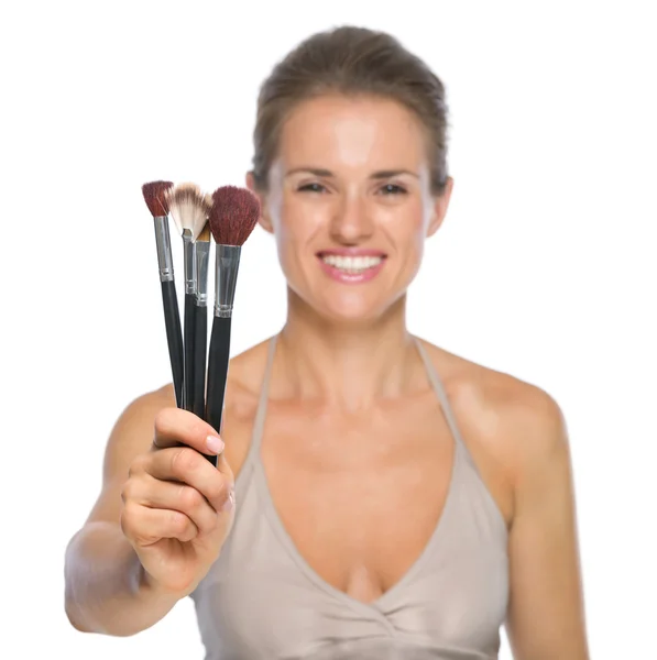 Woman showing makeup brushes — Stock Photo, Image