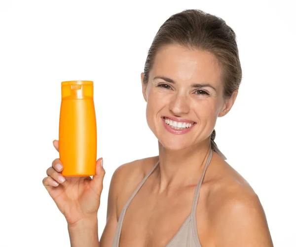 Woman showing bottle of sunscreen — Stock Photo, Image