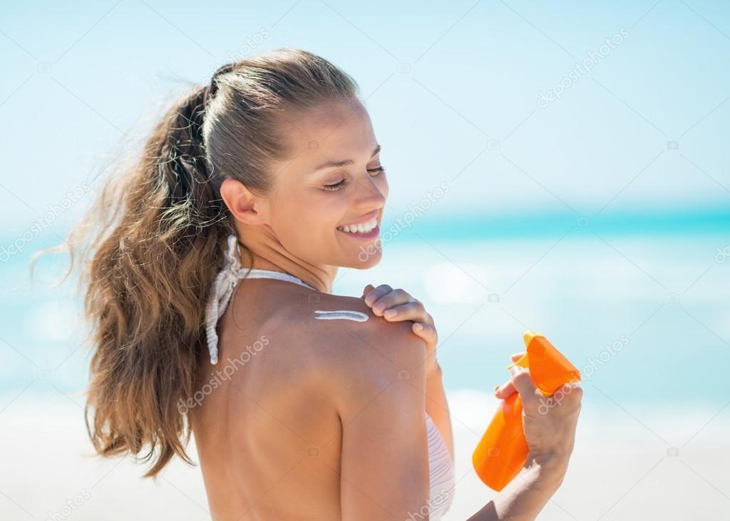 Woman applying sun screen creme
