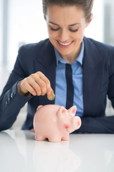 Mujer de negocios poniendo moneda — Foto de Stock